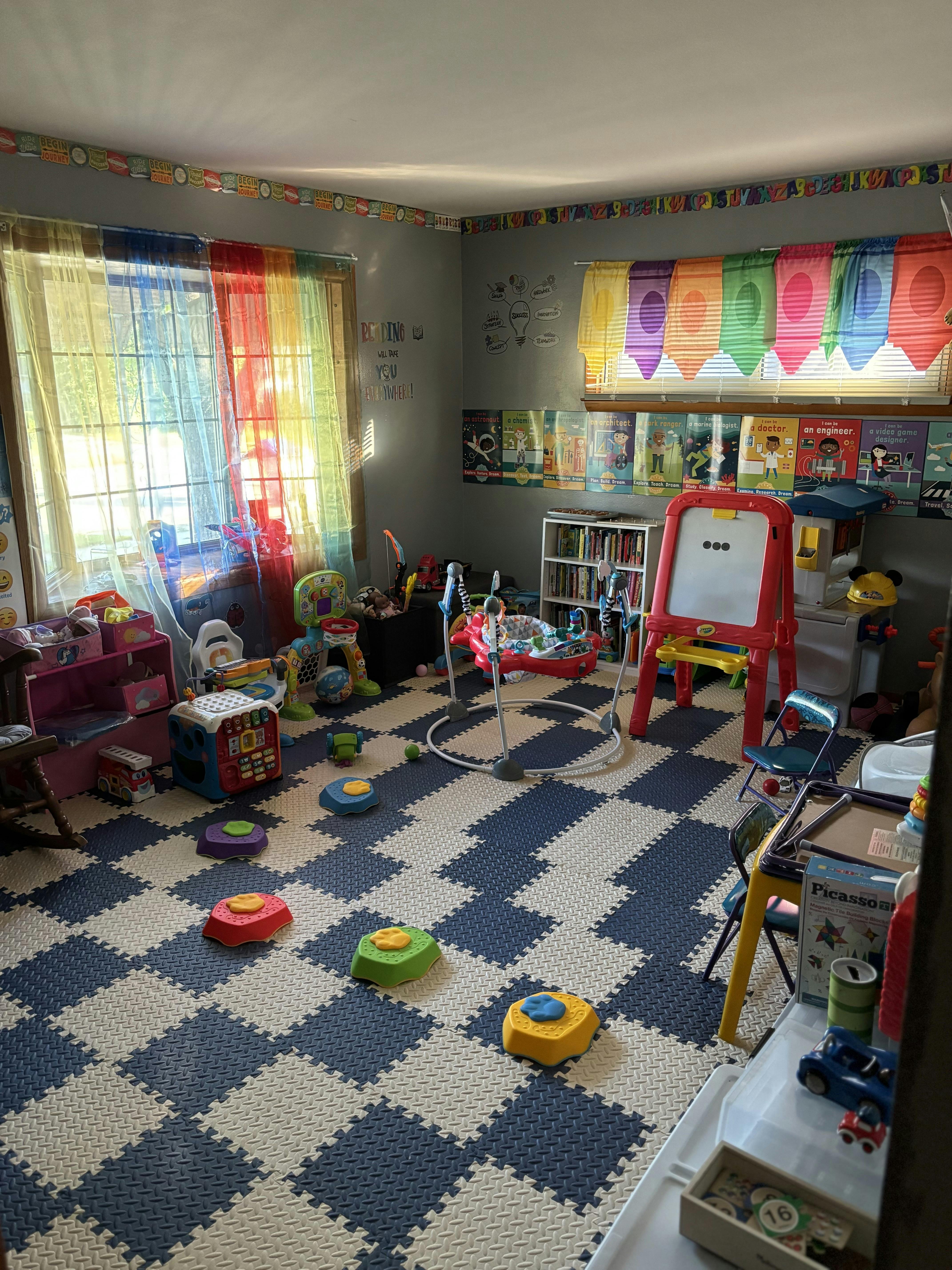 A playroom with colorful toys, a padded floor, and educational decorations