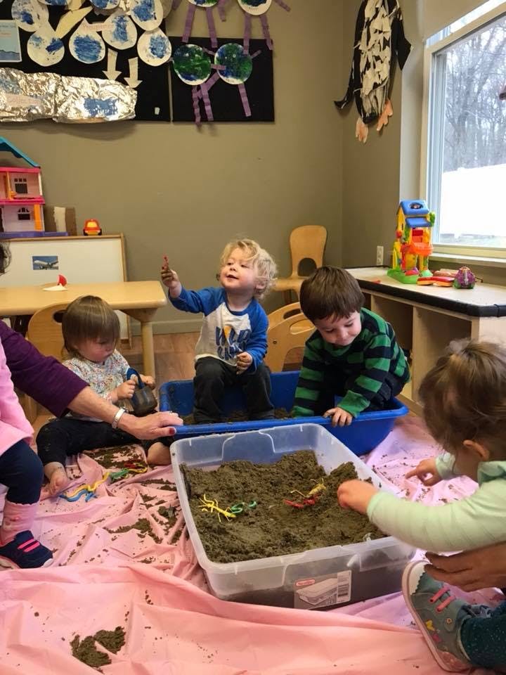 Children playing with kinetic sand in a classroom