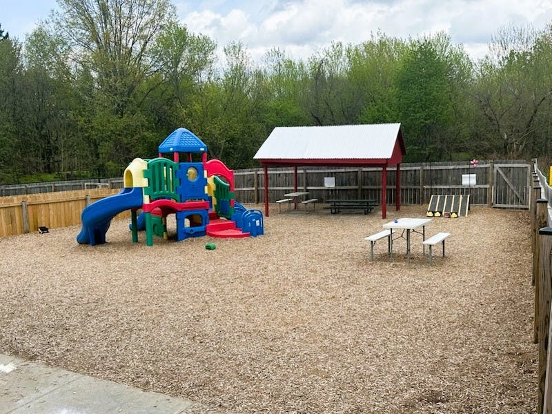 Outdoor playground with colorful slide structure and covered picnic area