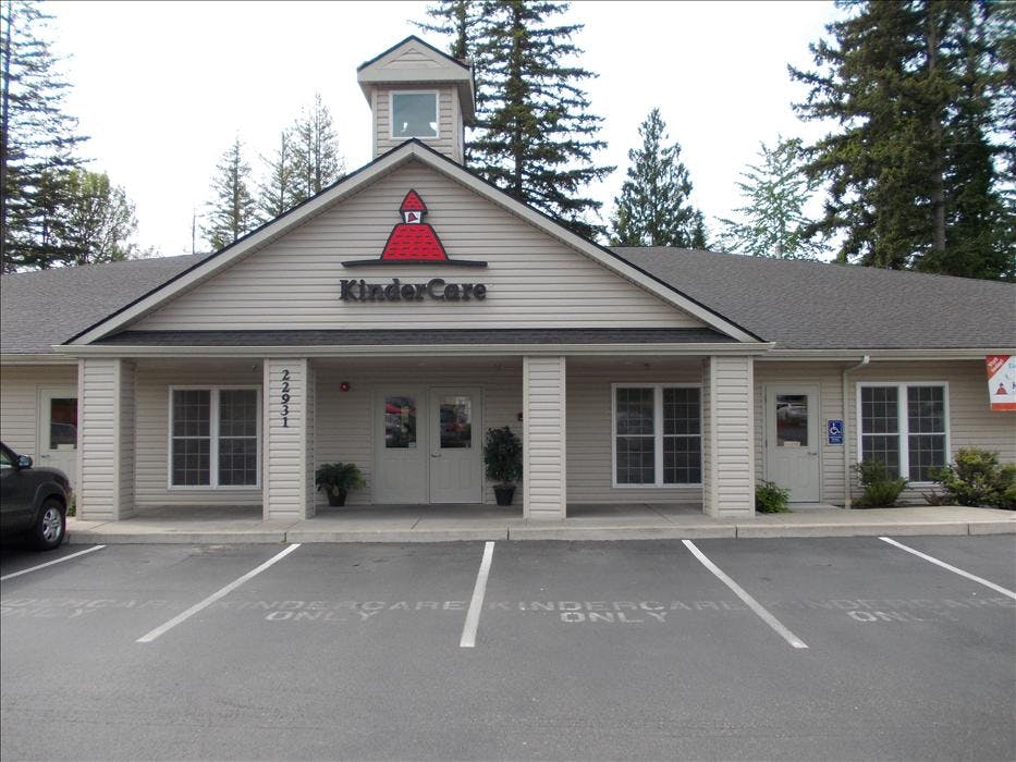 KinderCare building with a parking lot and trees in the background