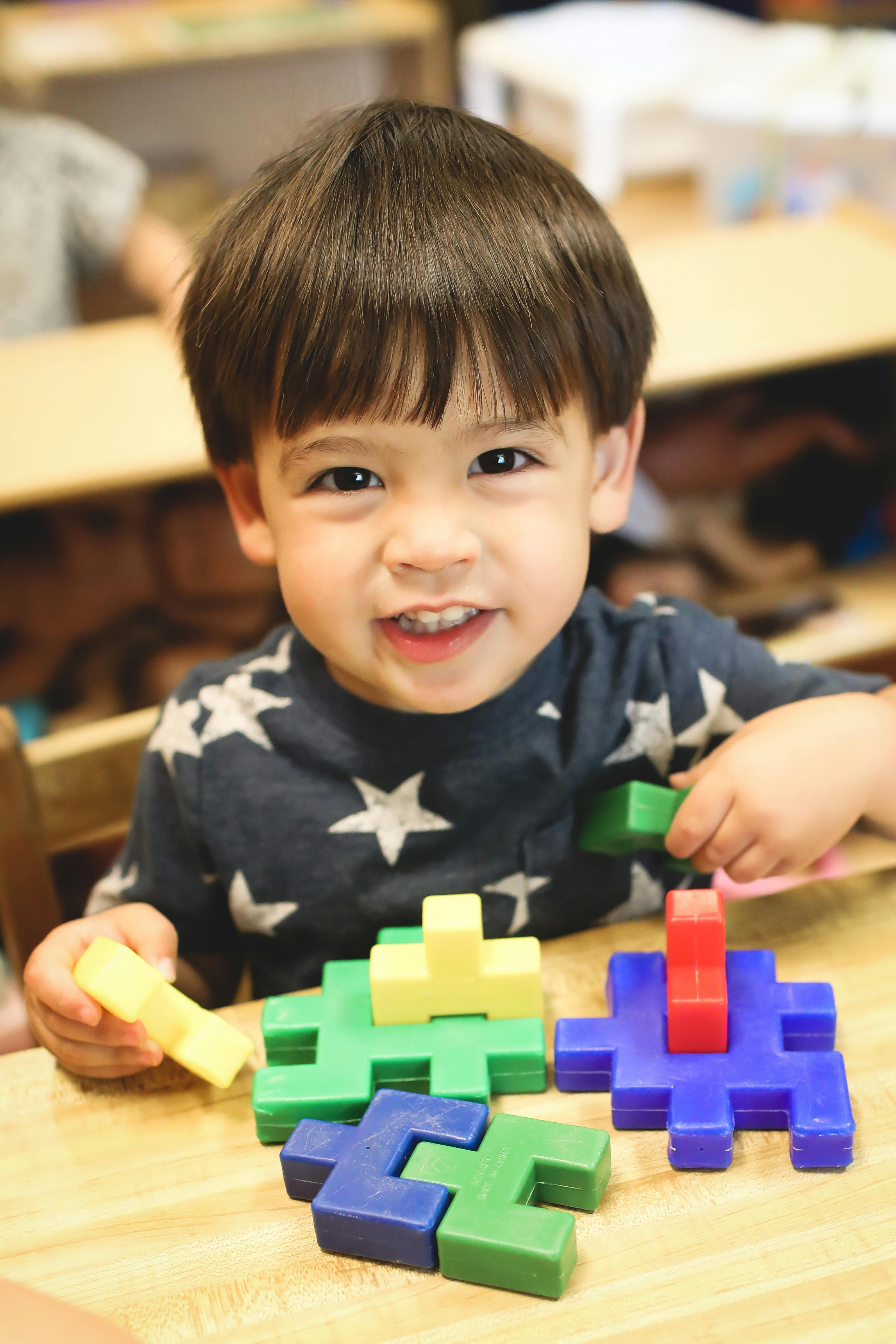 Child playing with colorful interlocking blocks at a table