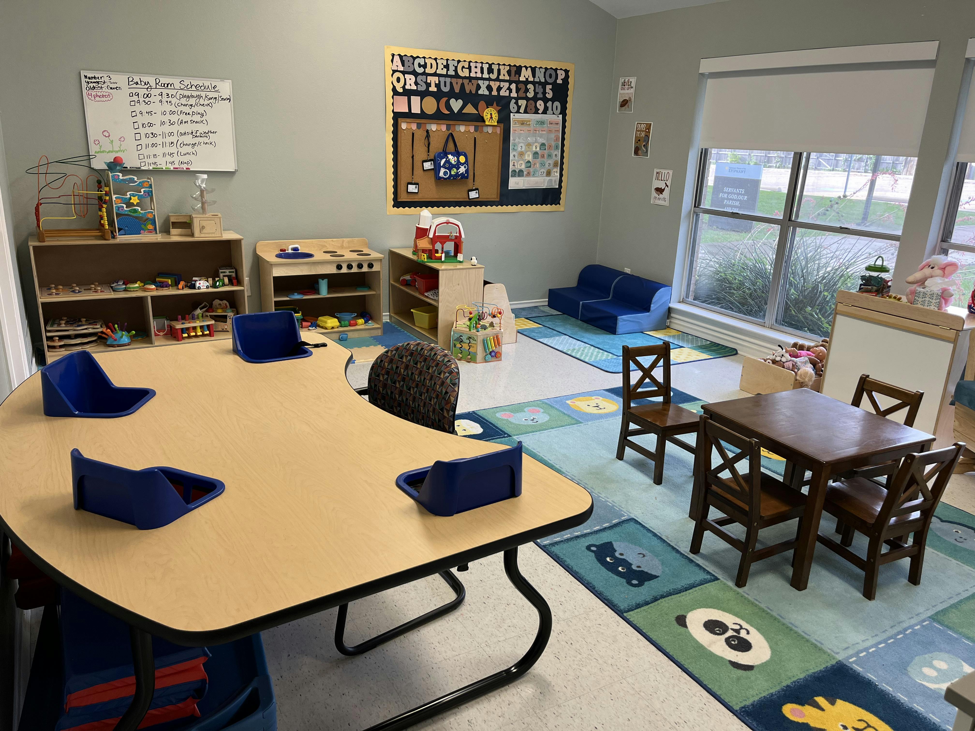 Classroom with small tables, chairs, and play areas