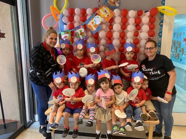 Two people with a group of children wearing paper crowns