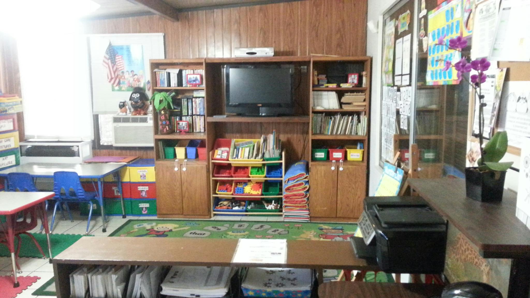 Classroom with a television, bookshelves, and small tables and chairs