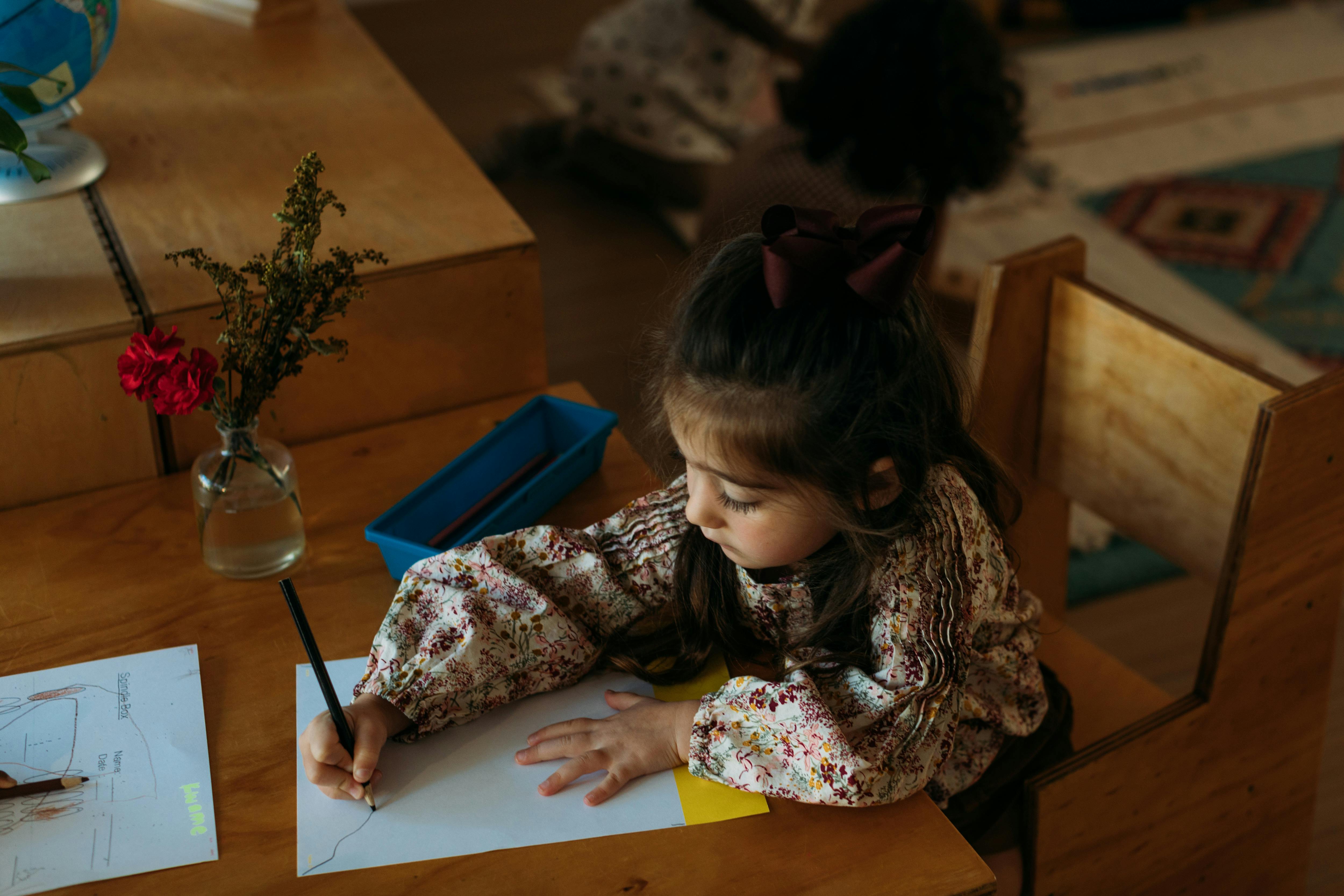 Child drawing on paper at a desk