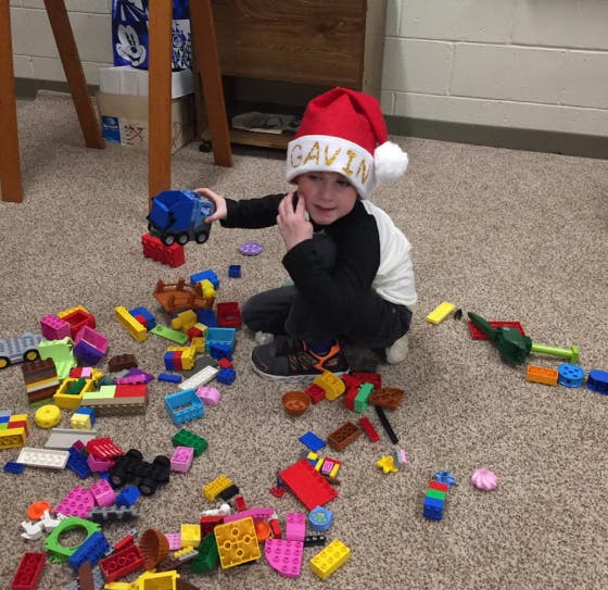 Child in a Santa hat playing with building blocks on the floor