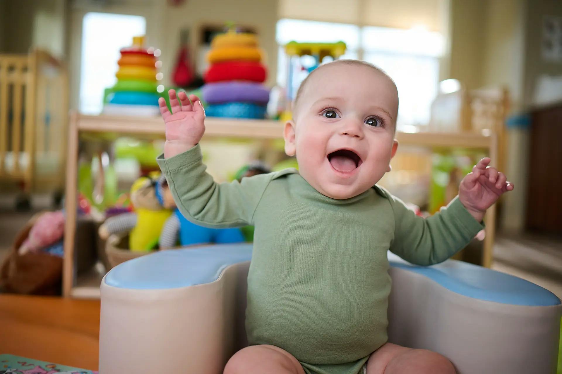 Child in a high chair with arms raised