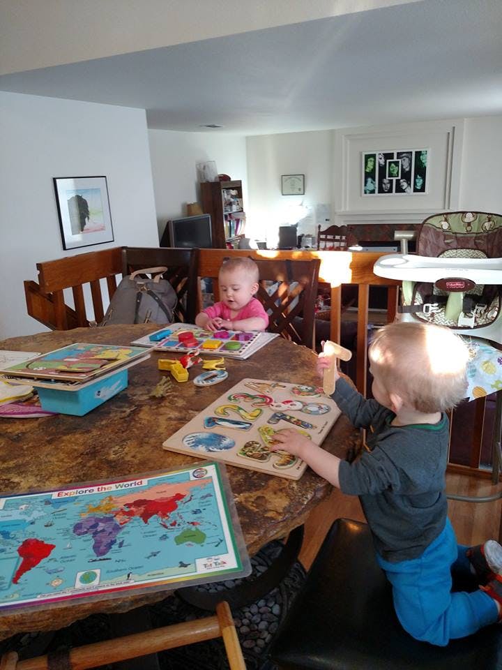 Two children playing with puzzles at a table