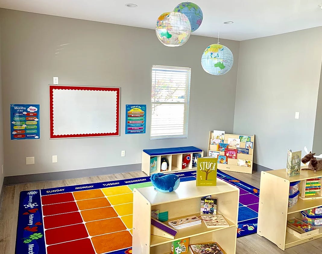 Classroom with colorful rug, whiteboard, and globe decorations