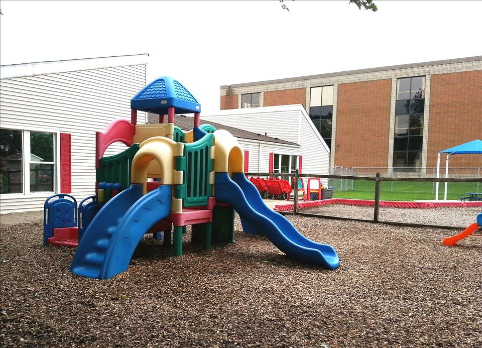 Colorful playground structure with slides on wood chip ground