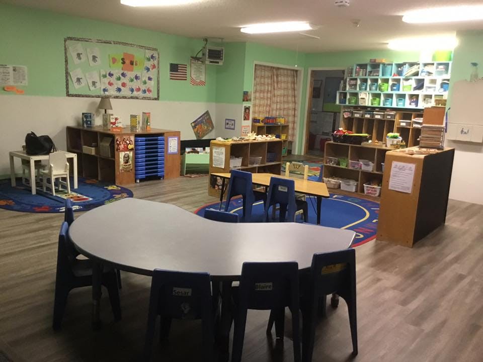 Empty classroom with tables, chairs, and shelves