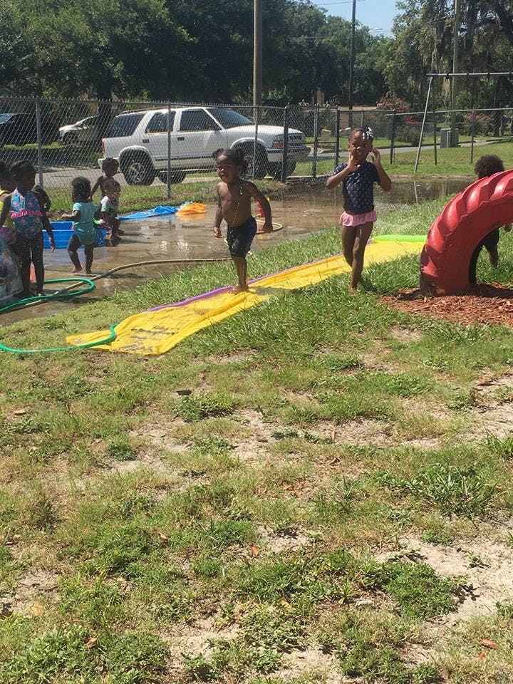 Children playing with water on a slip and slide