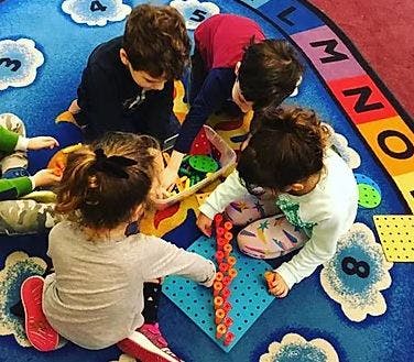 Children playing with toys on a colorful rug