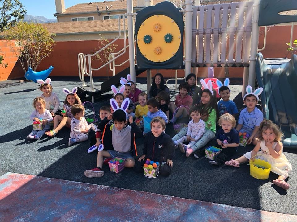 Group of children and adults wearing bunny ears on a playground