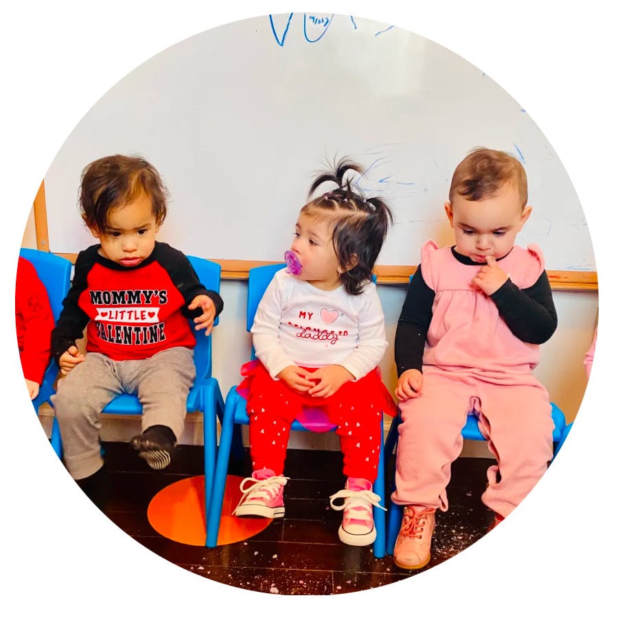 Three children sitting on small chairs
