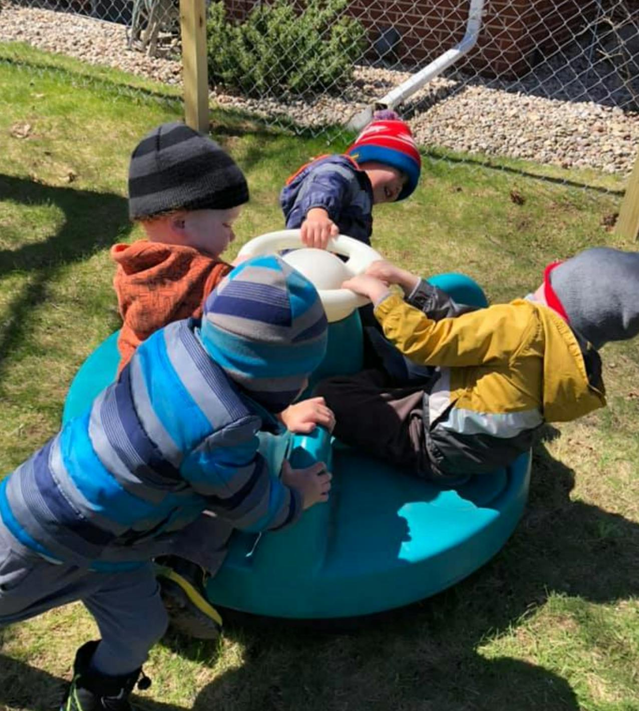 Children playing on a spinning toy outdoors