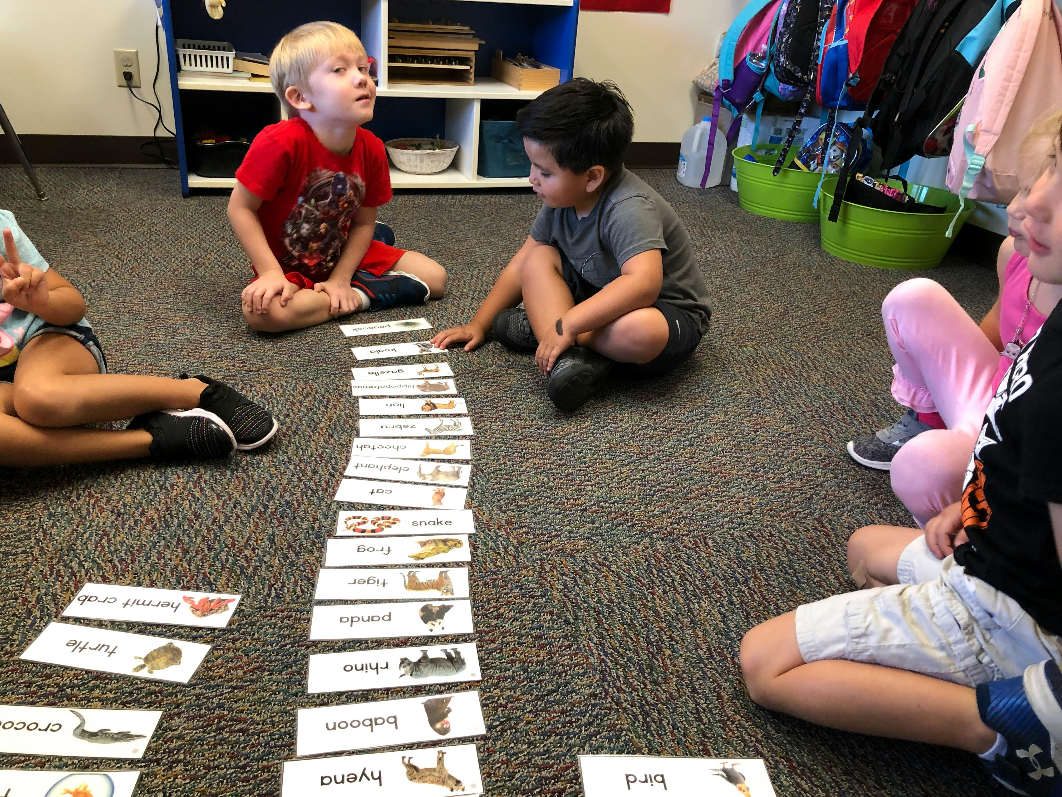 Children sitting on floor with animal picture cards