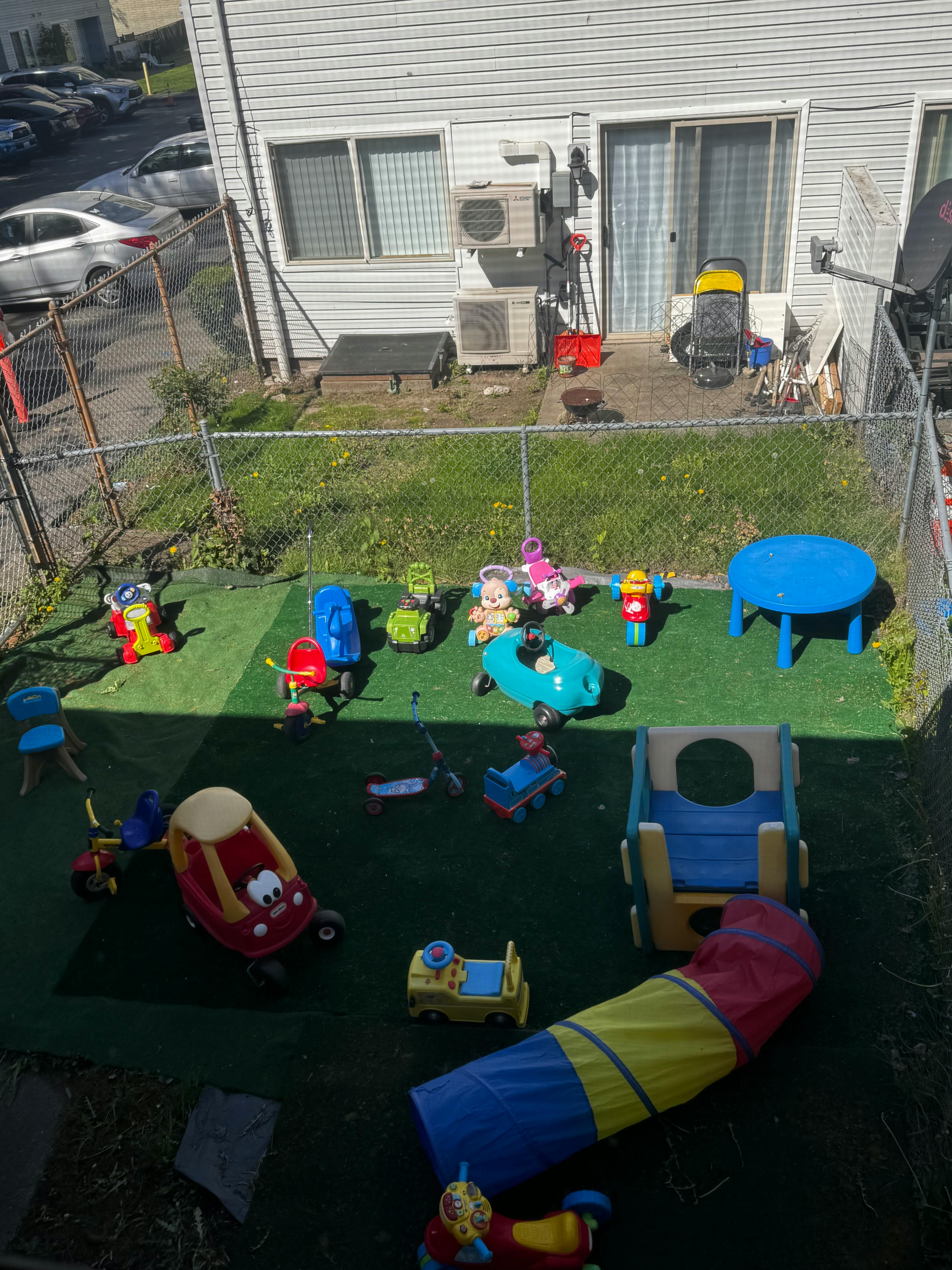 Outdoor play area with various ride-on toys and play equipment
