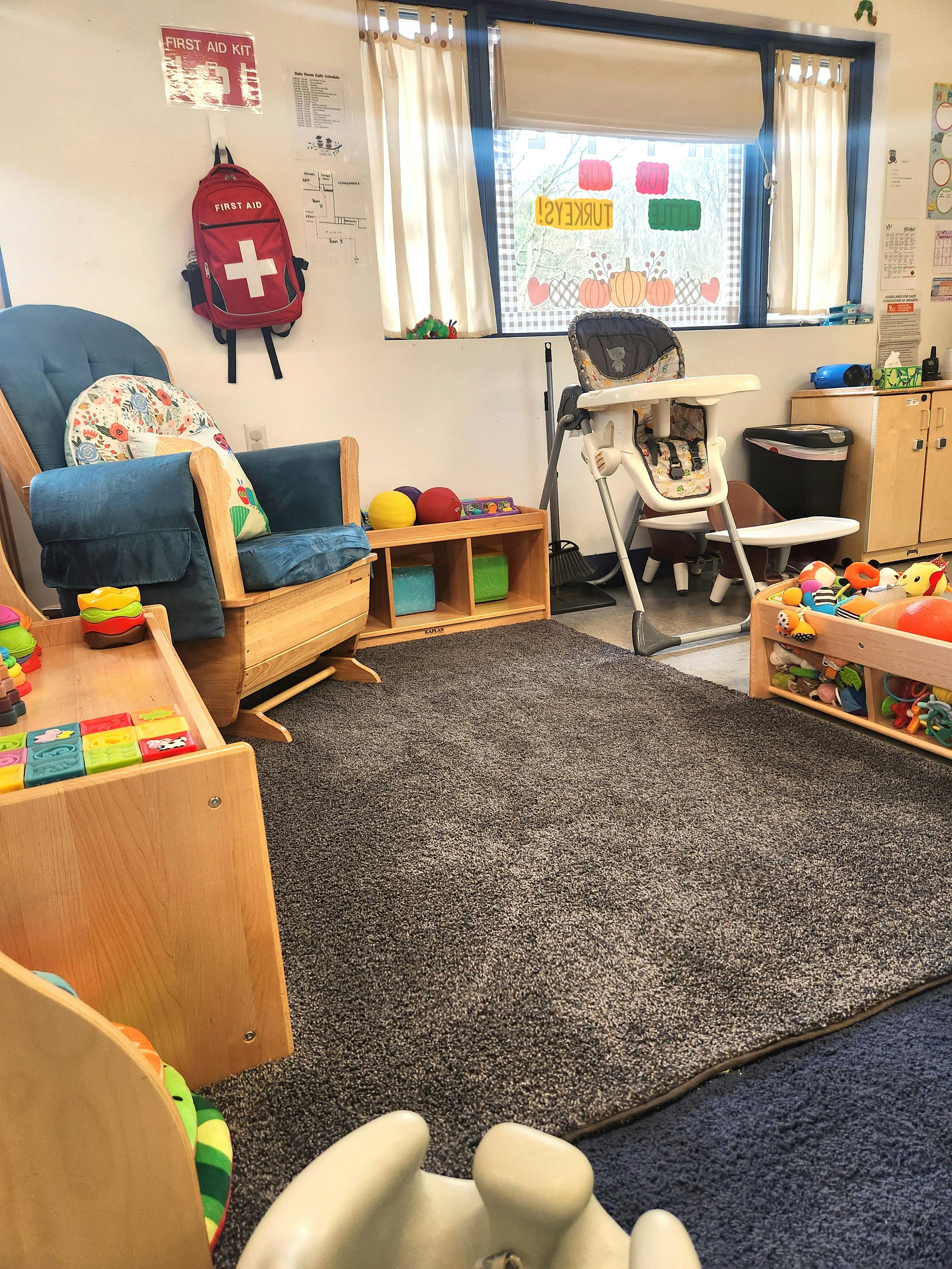 Classroom with a rocking chair, high chair, and play area