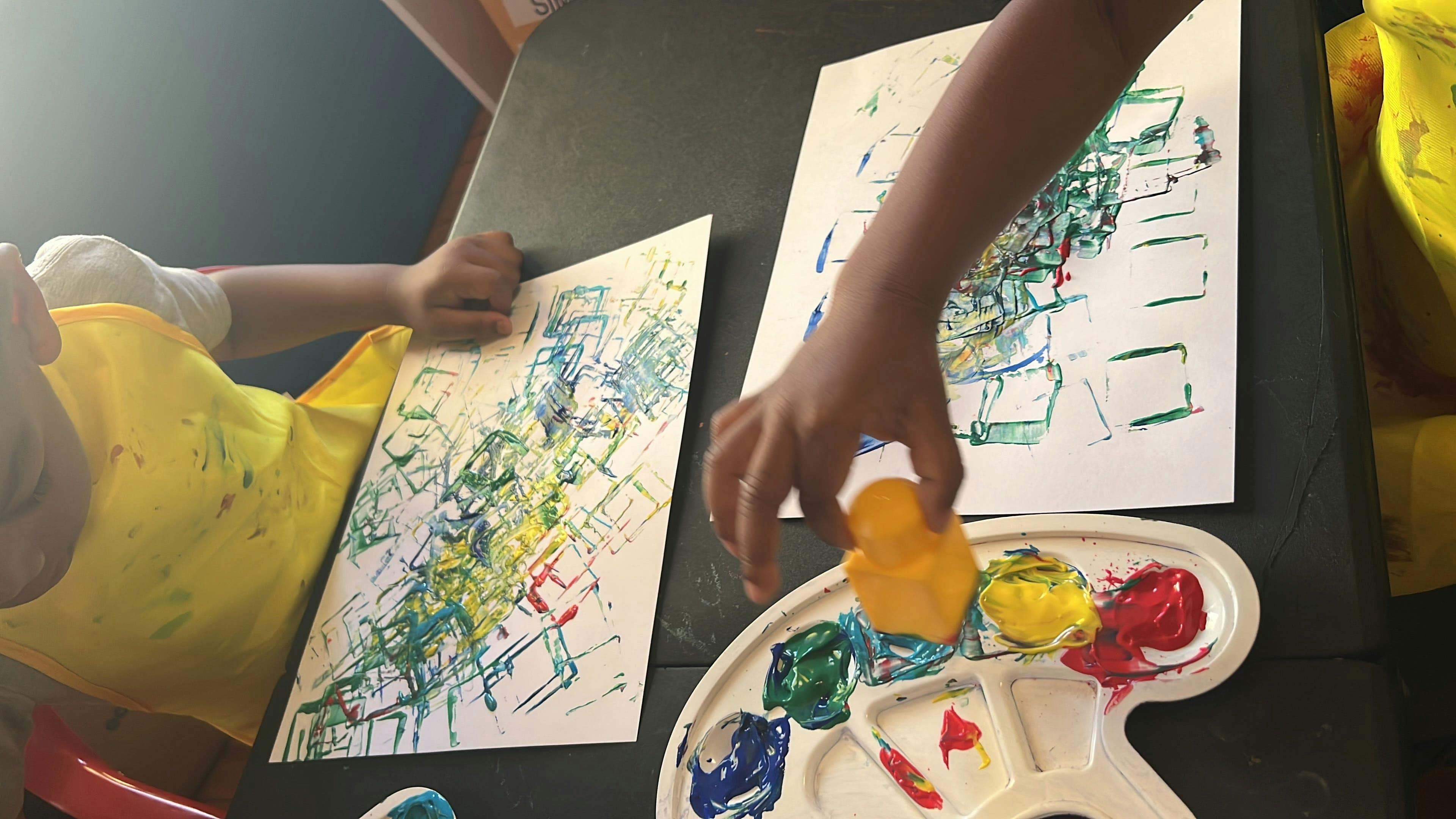 Child painting with a sponge and paint palette
