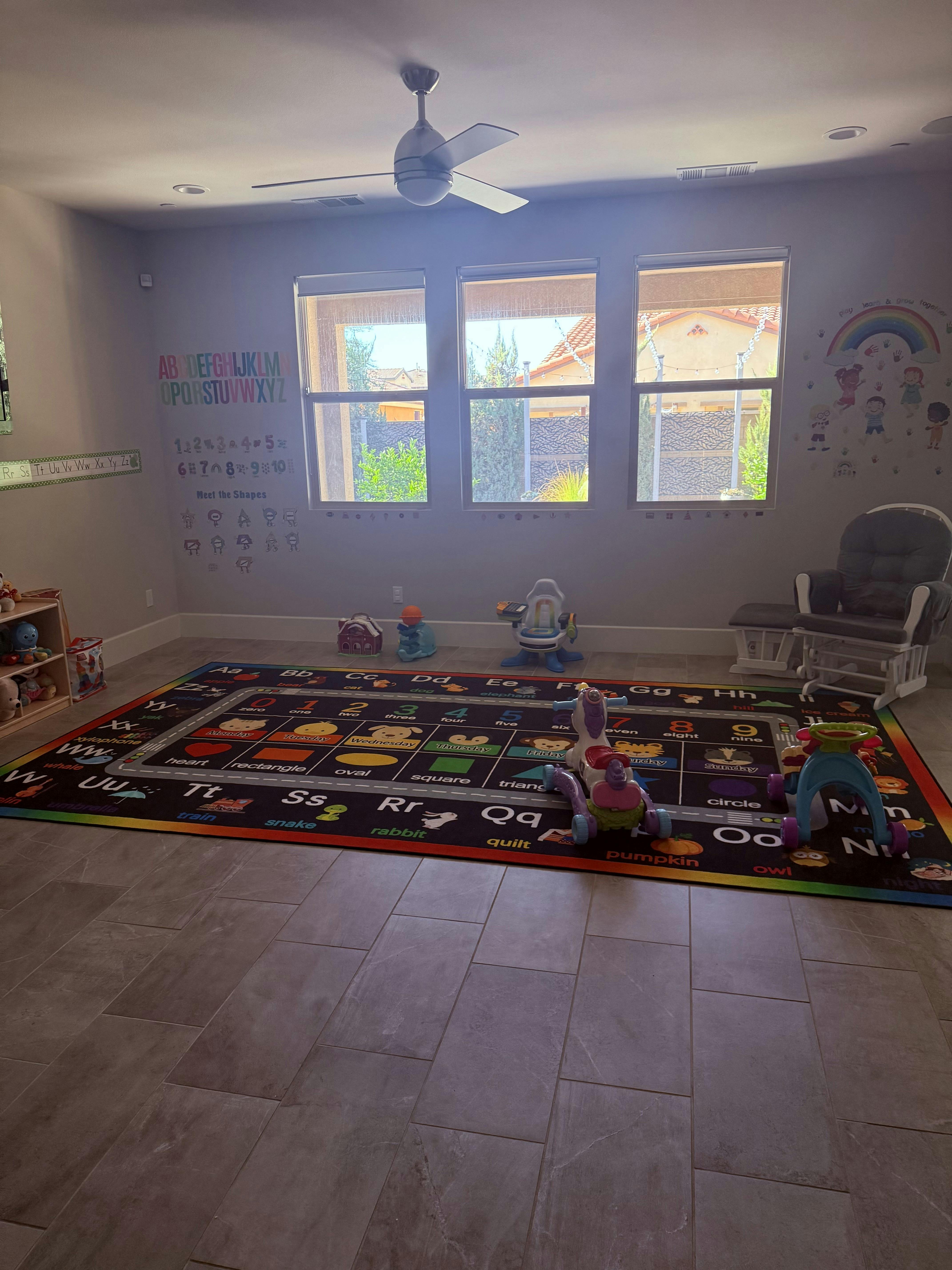 Playroom with an alphabet rug and various toys