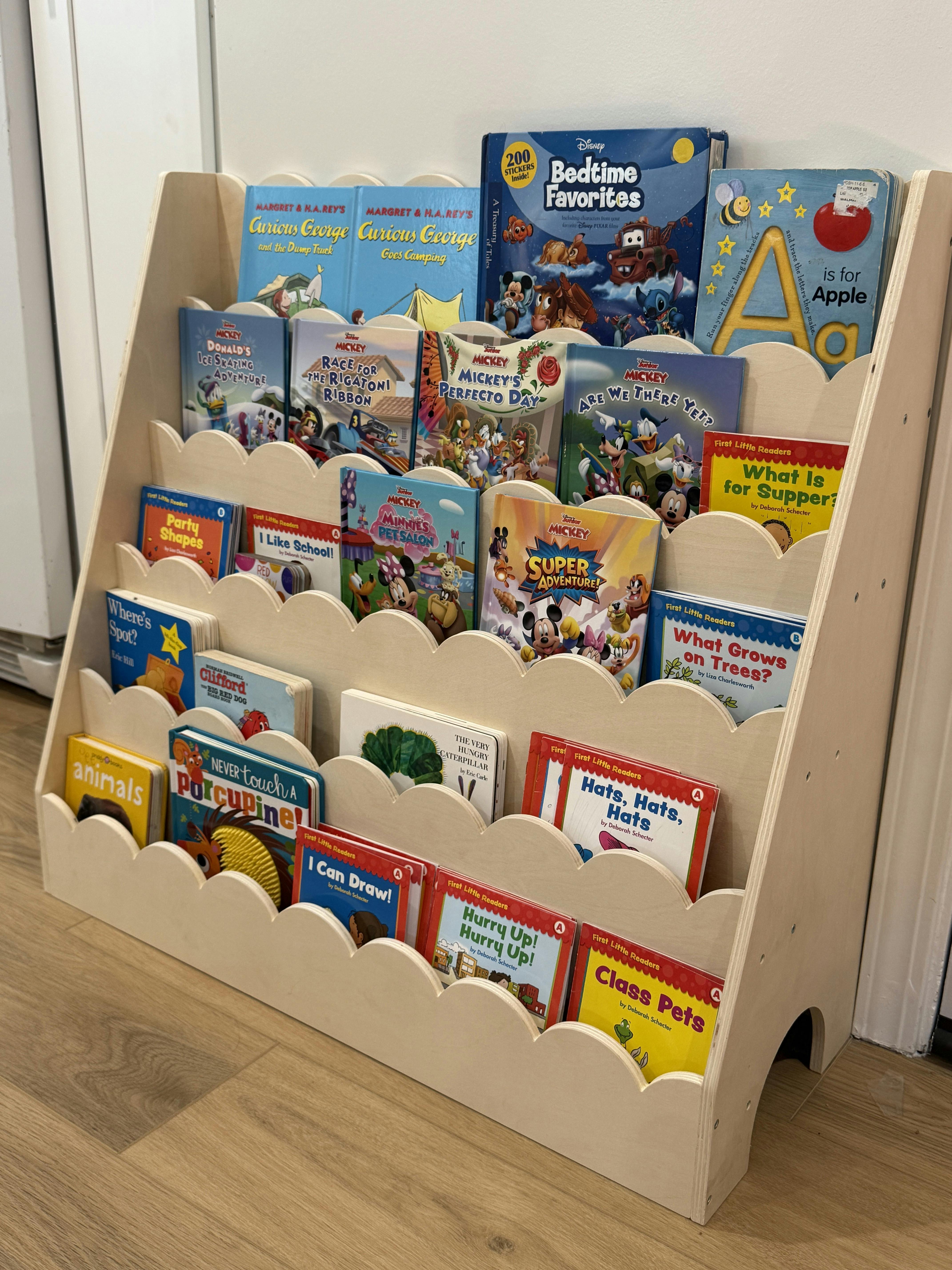 Children's books displayed on a wooden bookshelf