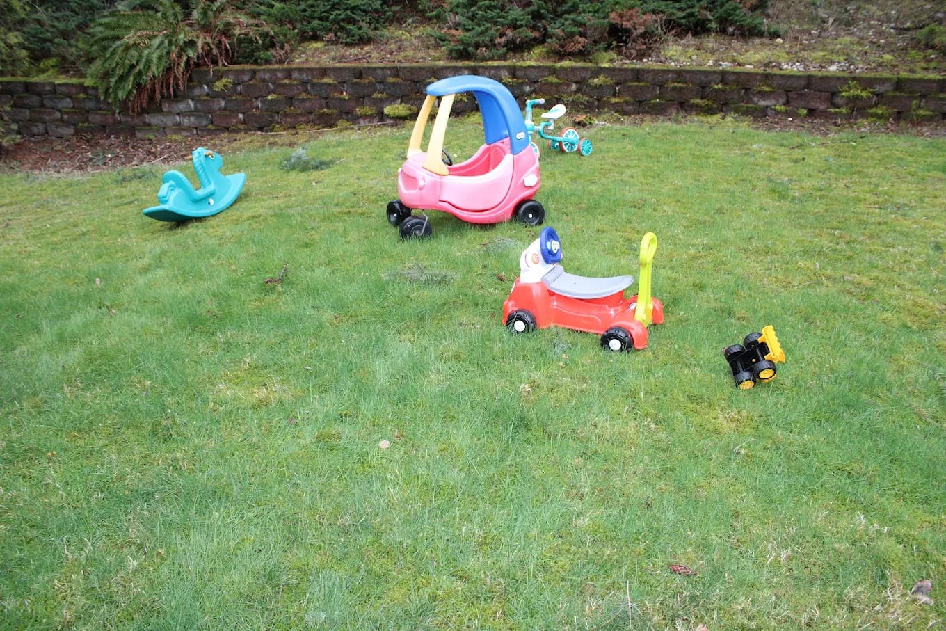 Children's ride-on toys on a grassy lawn