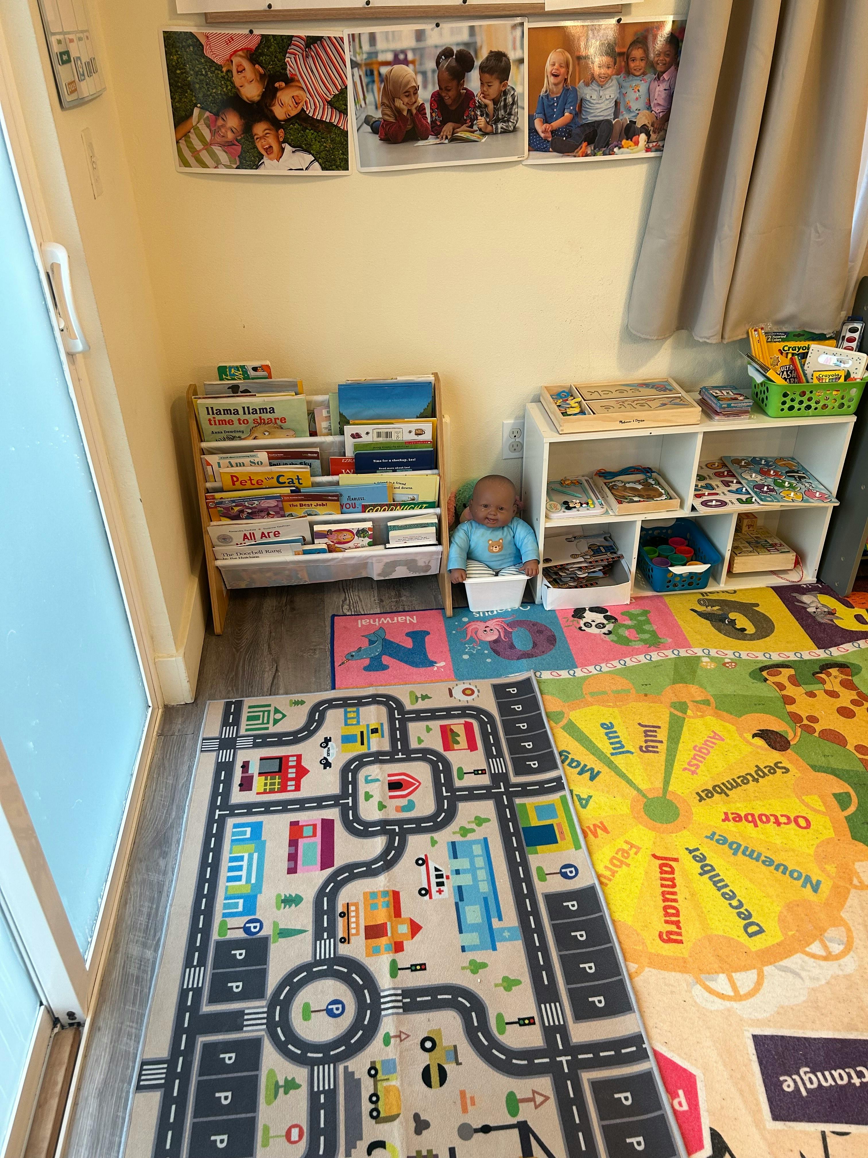 Children's play area with rugs, bookshelves, and a doll