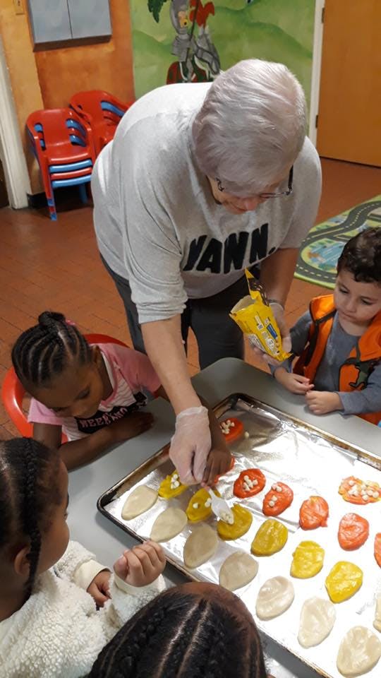 Person and children decorating cookies