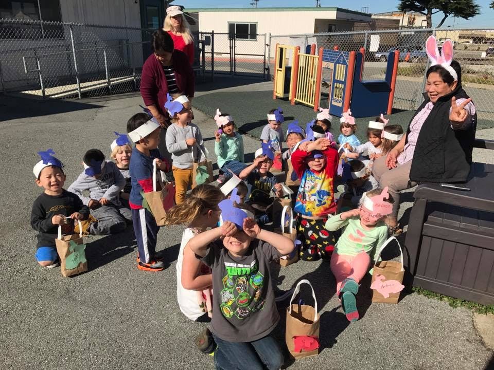Adults and children wearing headbands, some holding bags