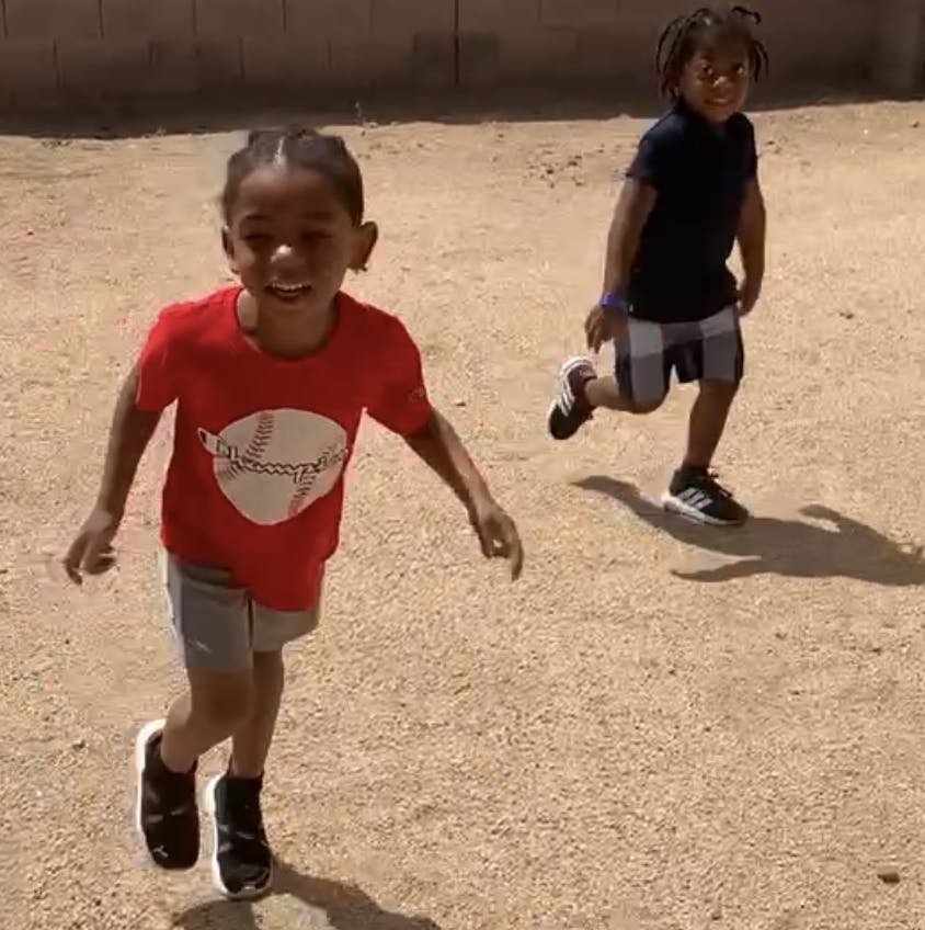 Two children running outdoors
