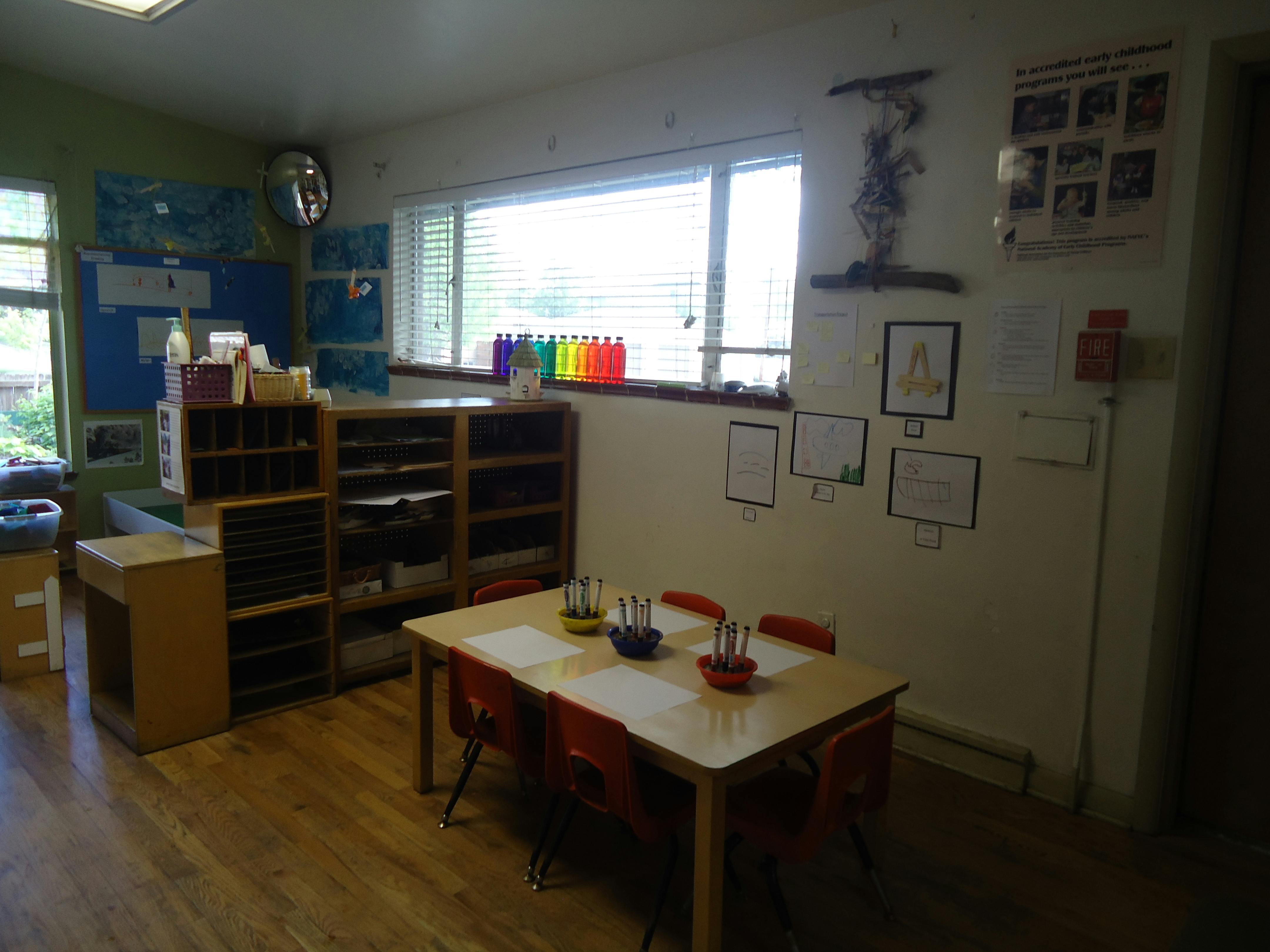Classroom with small table and chairs, storage shelves, and window