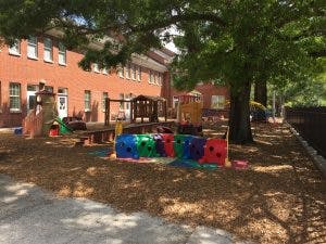 Playground with colorful equipment in front of a brick building