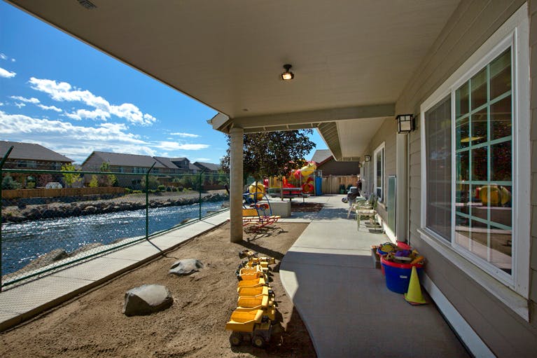 Outdoor patio with a river view and playground equipment