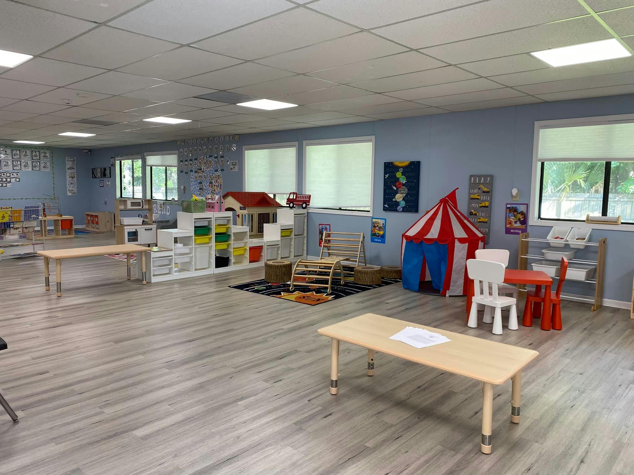 Classroom with play tent, small tables and chairs, and learning materials