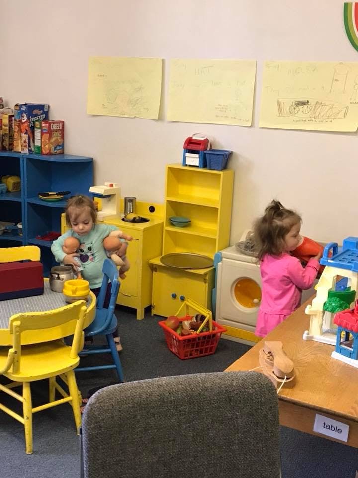 Two children playing with toys in a room