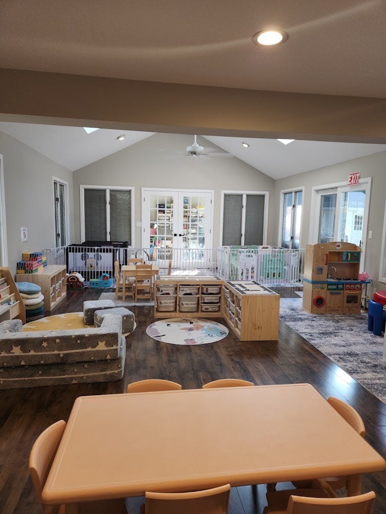 A playroom with small tables, chairs, and play areas