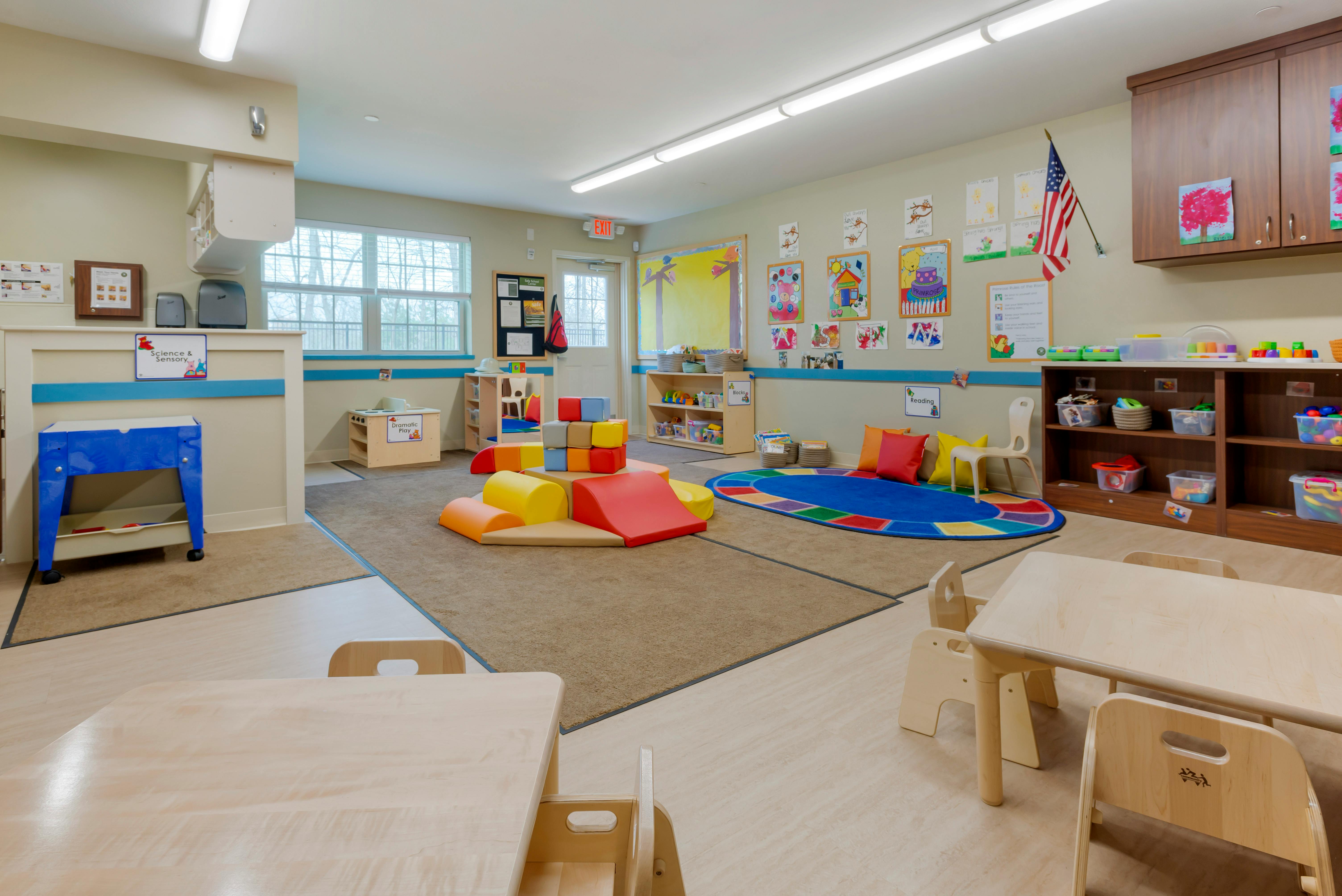 Colorful playroom with soft play structures and small tables and chairs