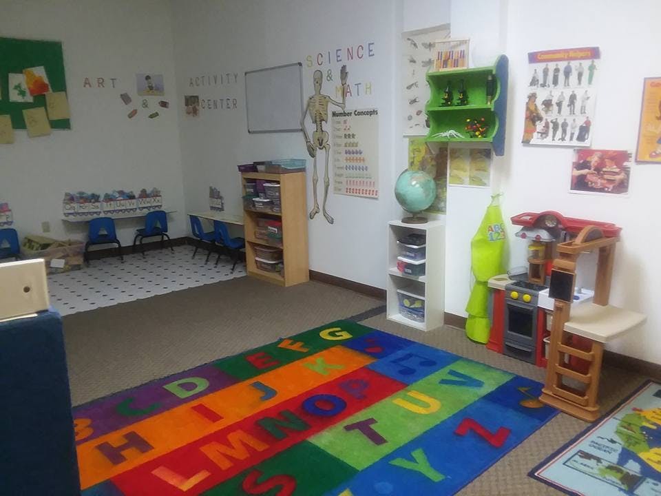 Classroom with alphabet rug, small chairs, and educational posters