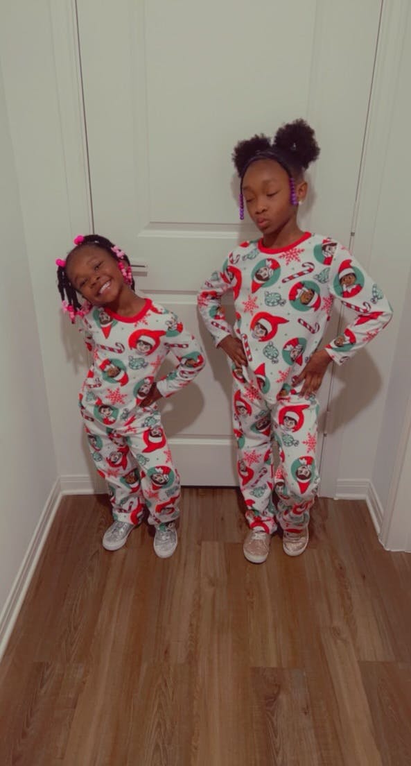 Two children in matching pajamas with holiday-themed pajamas