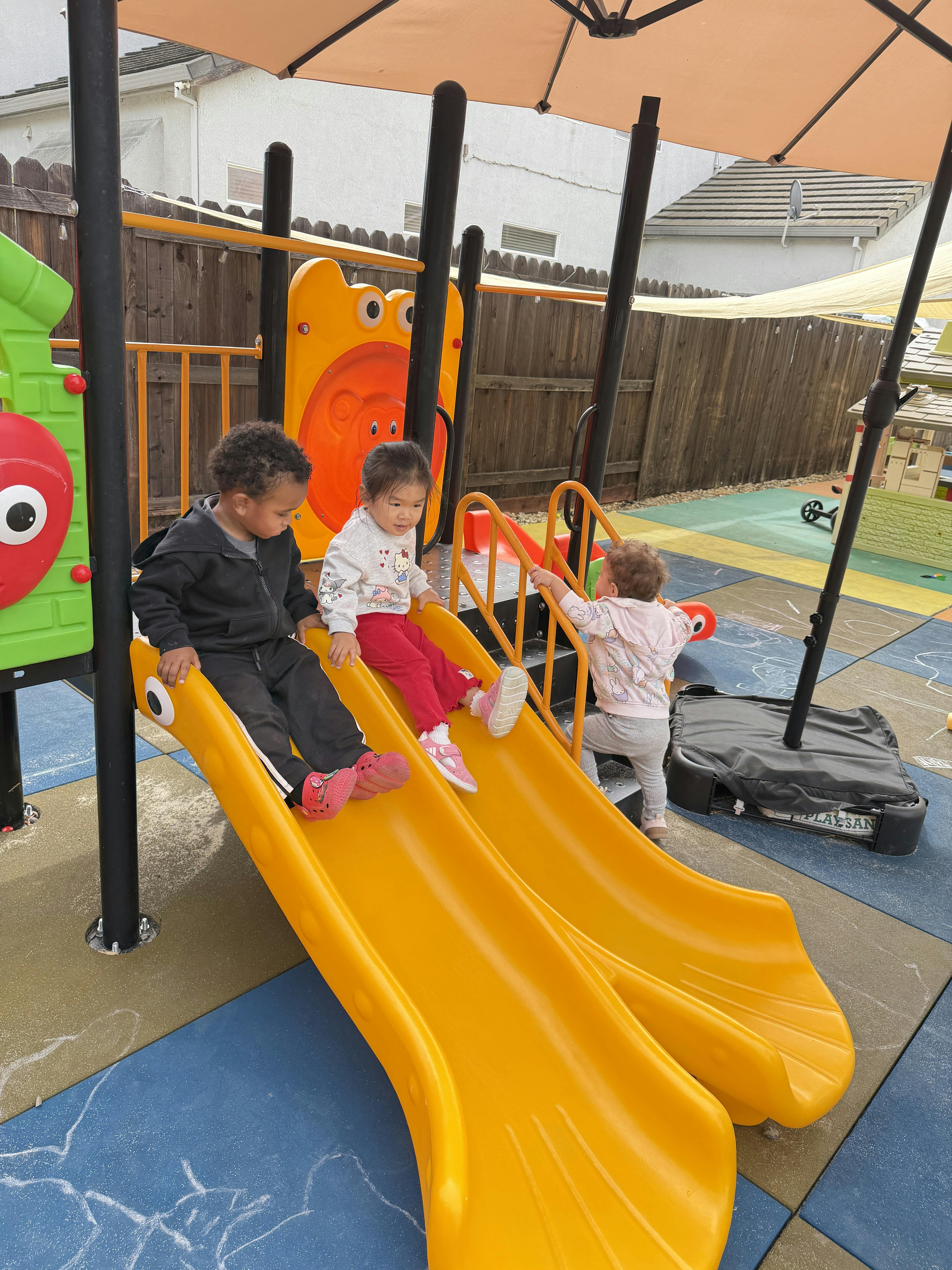 Children playing on a yellow playground slide