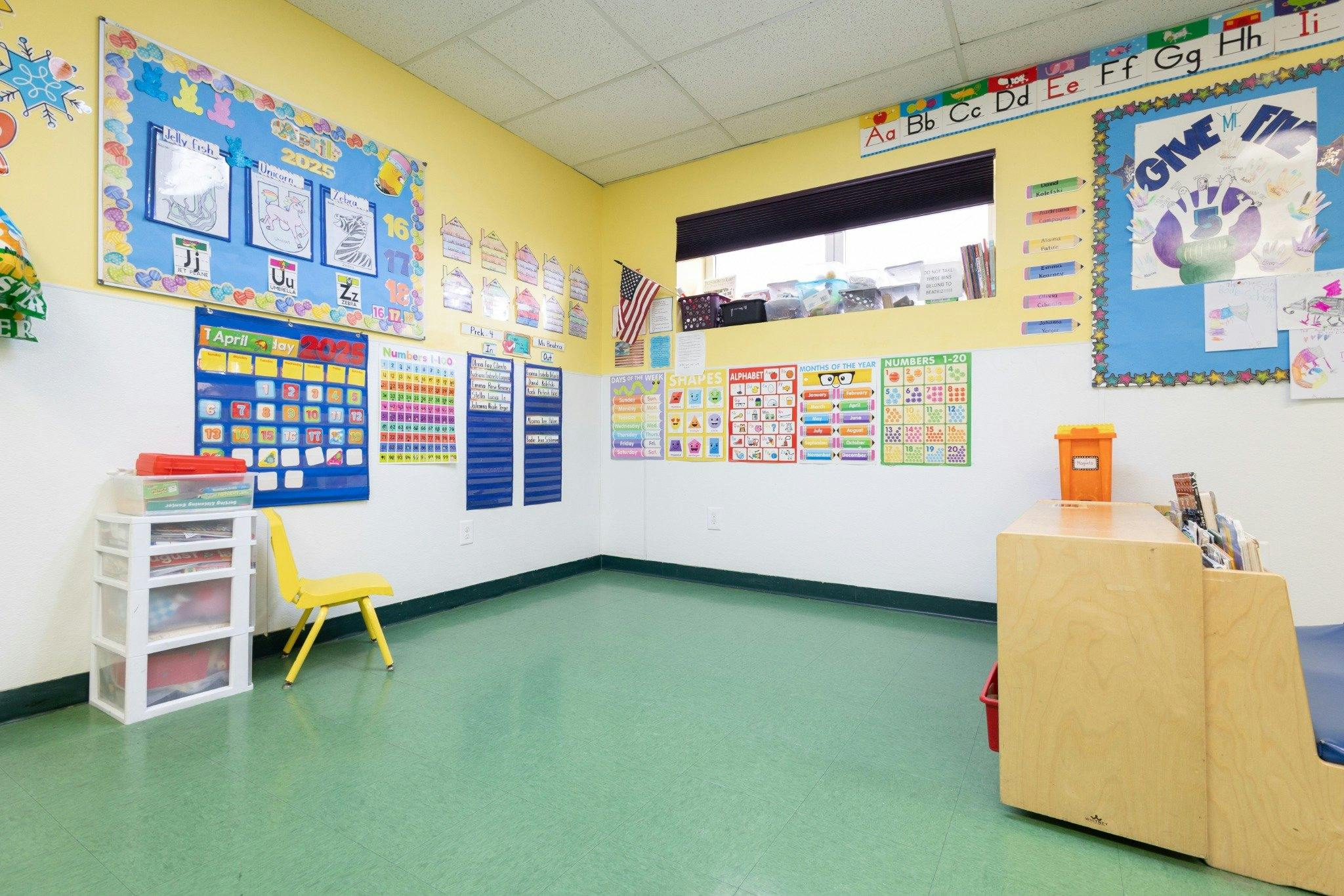 Classroom interior with educational posters and charts on yellow and white walls