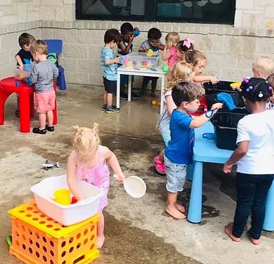 Children playing with water and toys outdoors