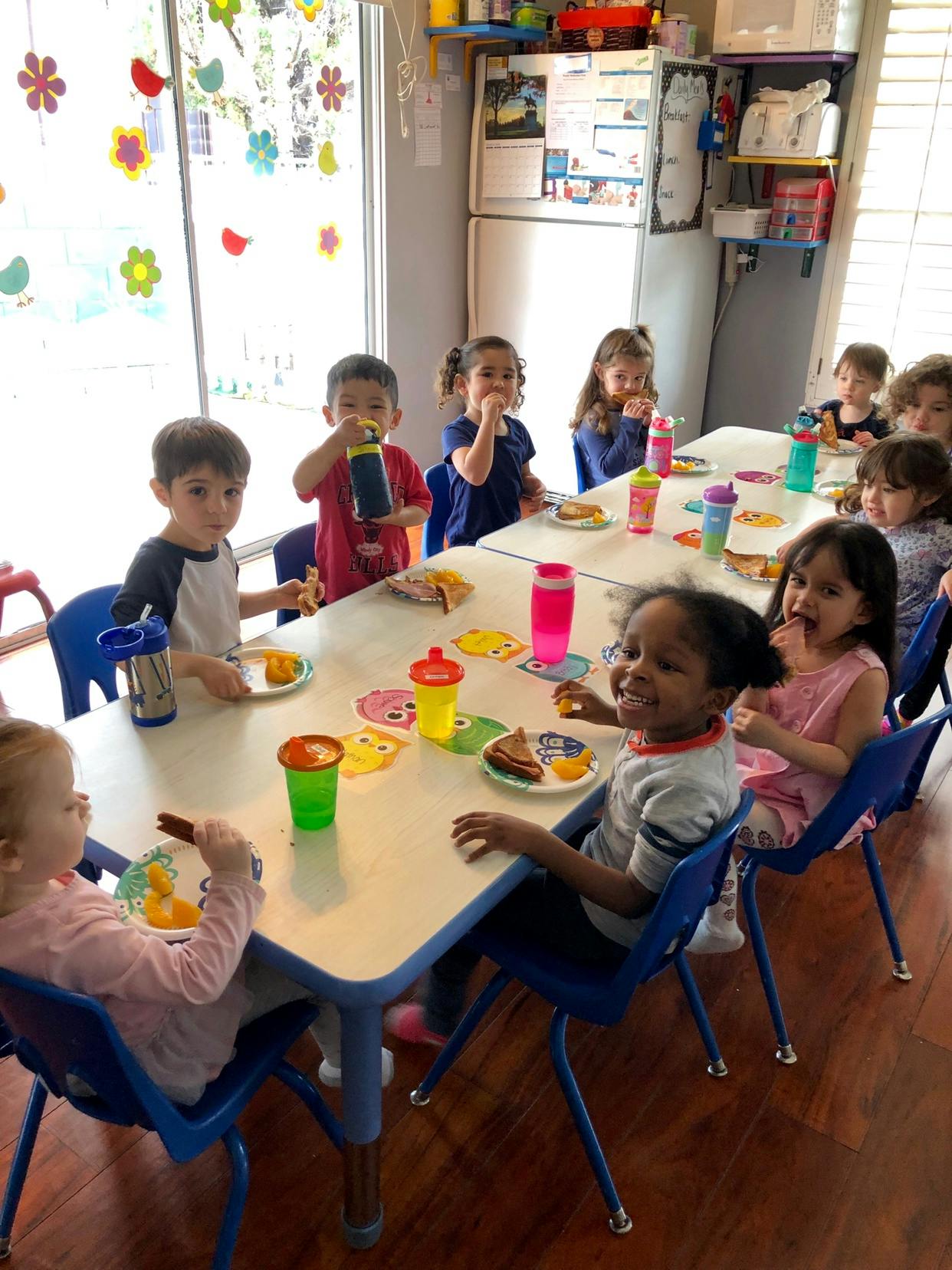 Children sitting at tables eating snacks