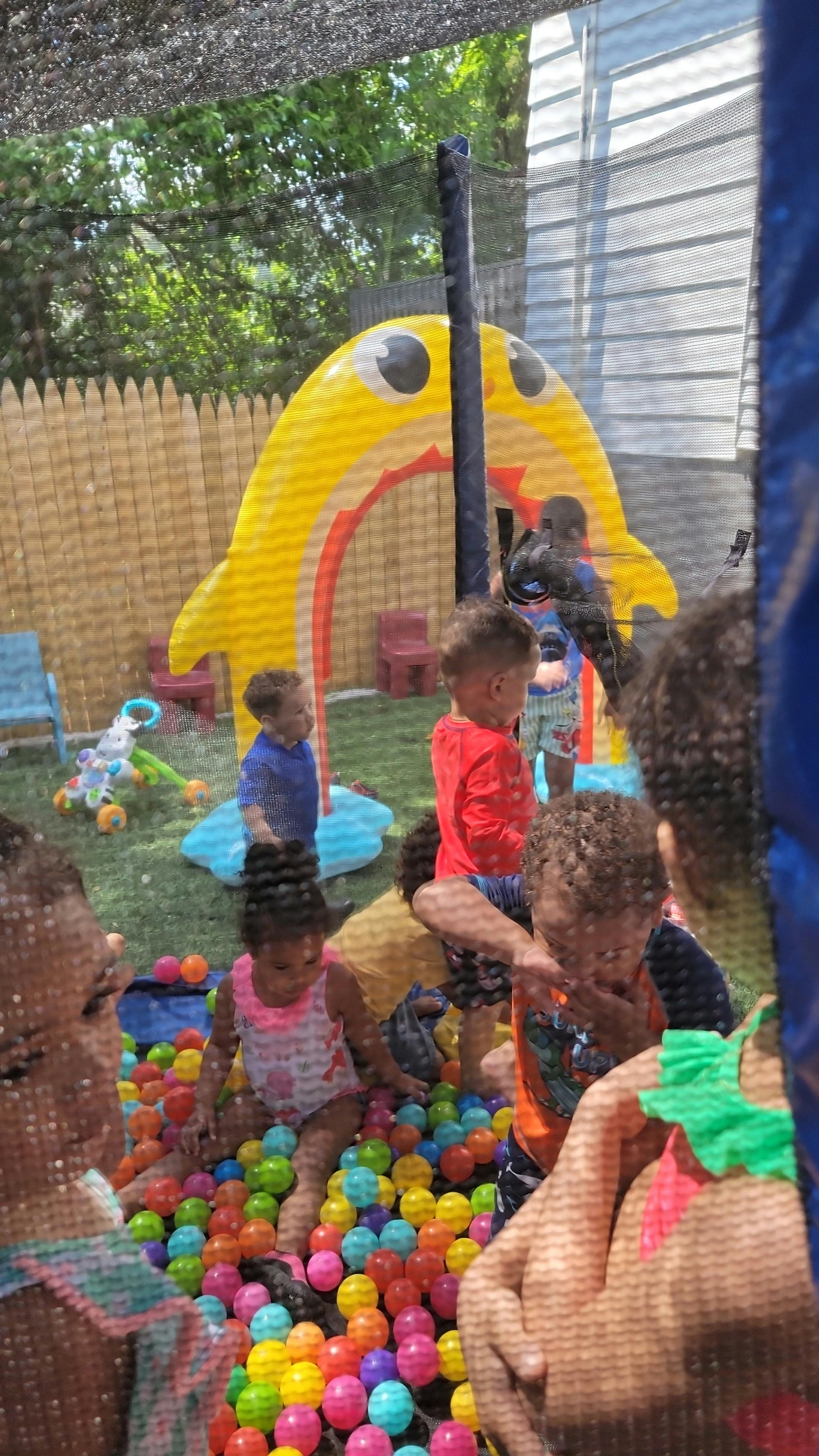 Children playing in a ball pit near a yellow inflatable structure