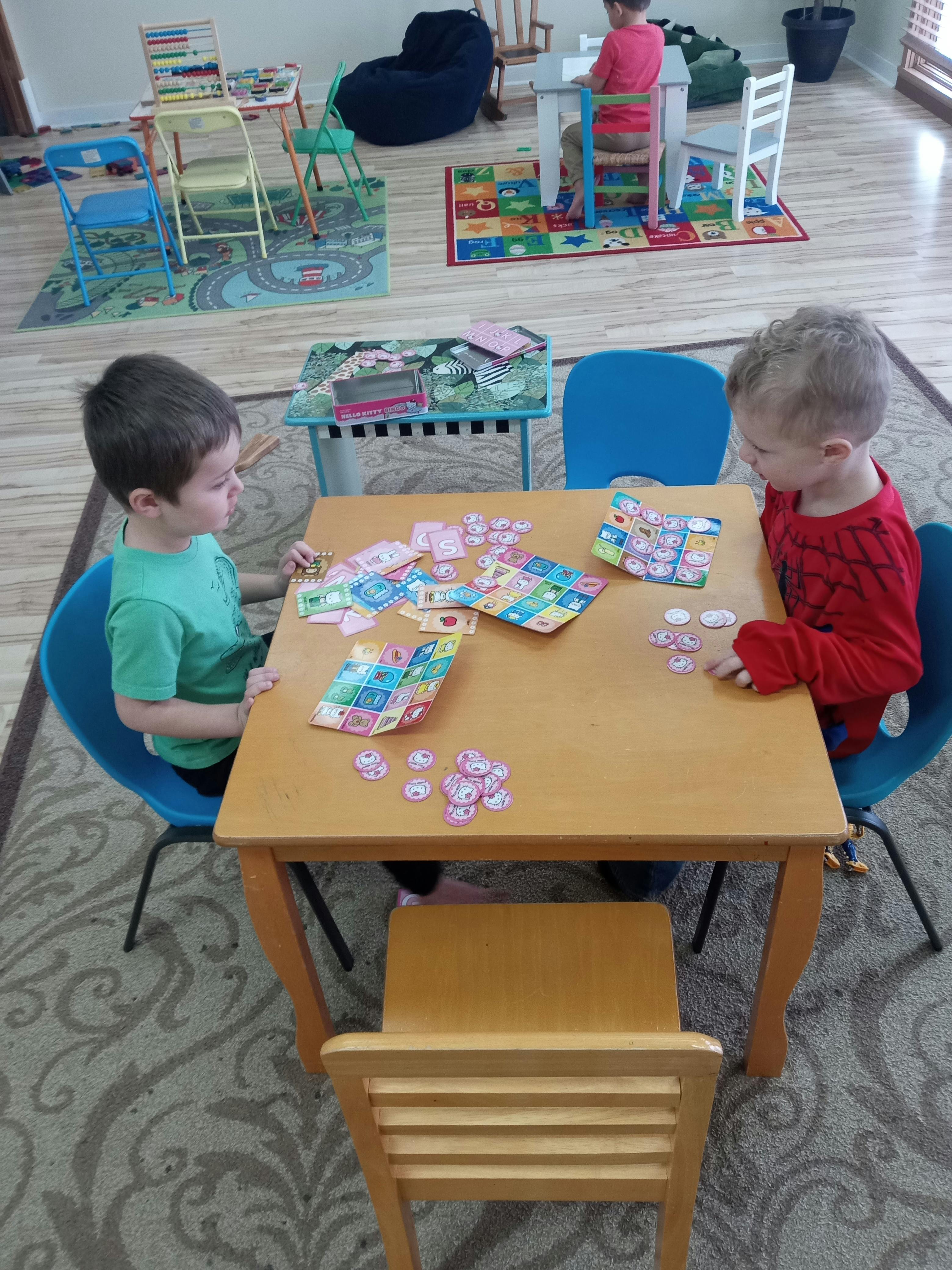 Two children playing with small items at a table