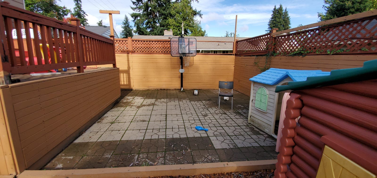 Patio with a small playhouse and basketball hoop