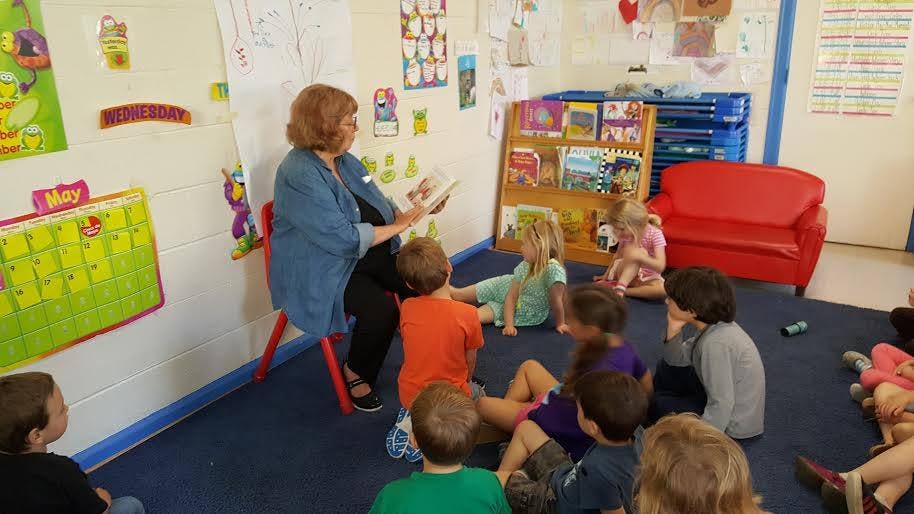 Person reading to children in a classroom
