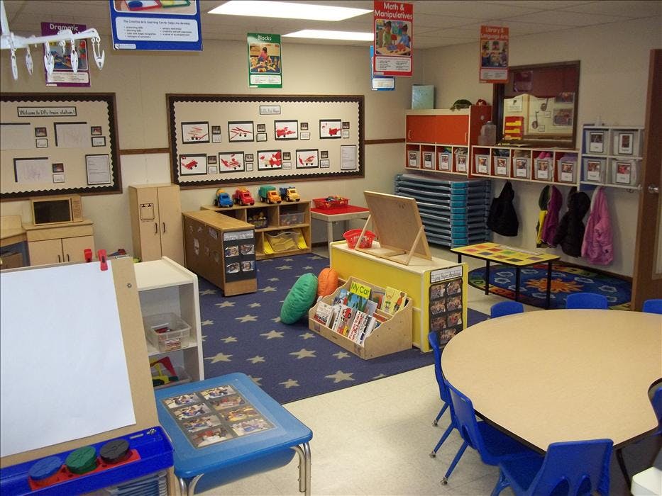 Classroom with play areas, tables, chairs, and learning displays