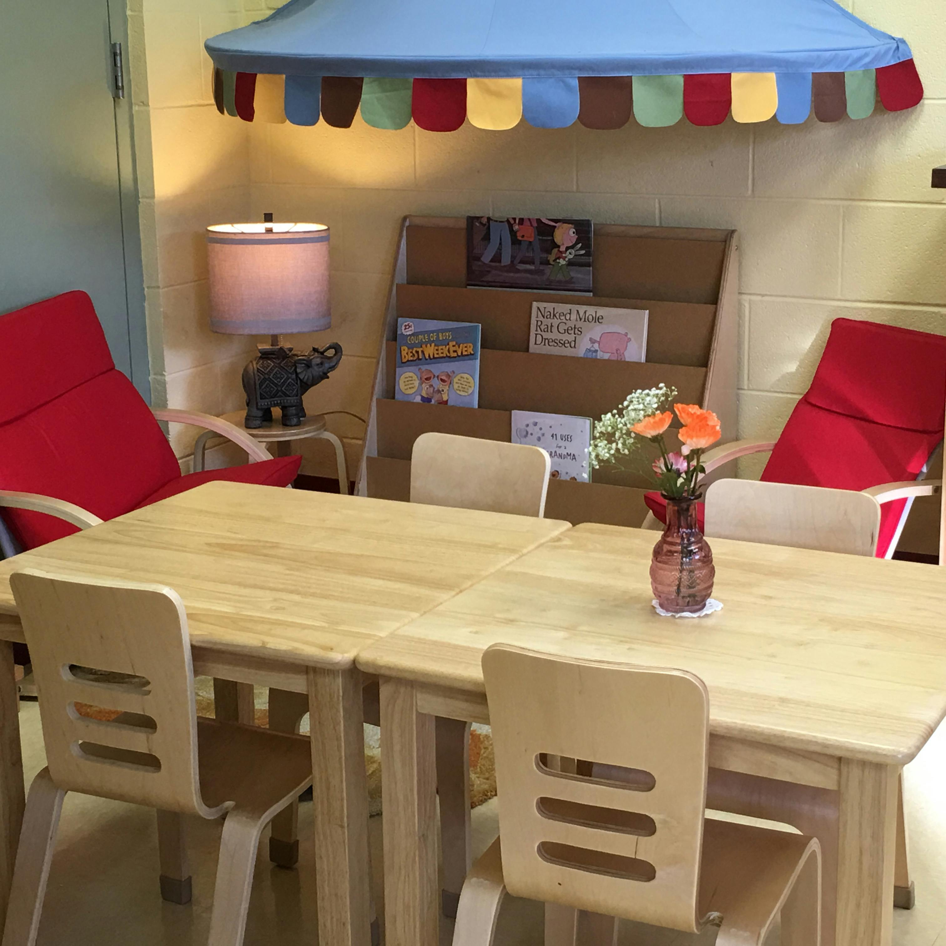 Small wooden tables and chairs in a classroom setting